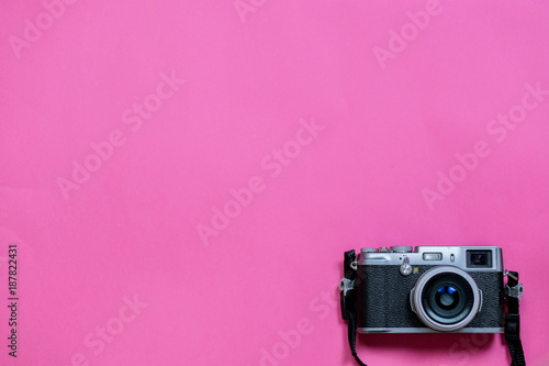 Vintage photo camera on Valentine's Day pink background with composition of blank photo frames, empty notes and hearts, top view. flat lay