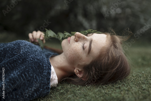 Girl with freckles laying in grass photo