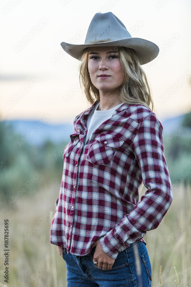 Portrait of smiling Caucasian teenage girl wearing cowboy hat at sunset Stock Photo Adobe Stock