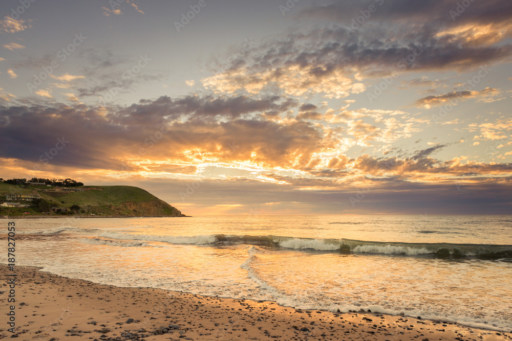Obraz premium Colourful sunset at the beach with pebbles in Myponga Beach South Australia