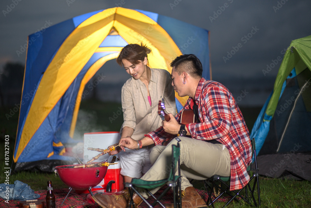 adventure couple lover enjoy grilling barbecue in font of tents living over night, happy tourist adventure stay at lake after sunset dinner bbq adventure couple lover enjoy grilling barbecue in font of tents living over night, happy tourist adventure stay at lake after sunset dinner bbq