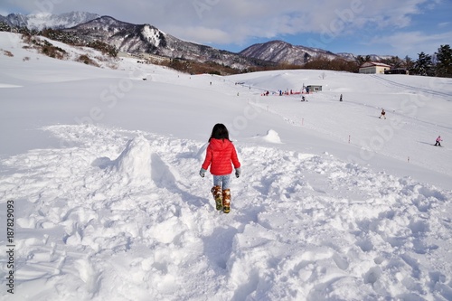 雪原で雪遊びをする子供