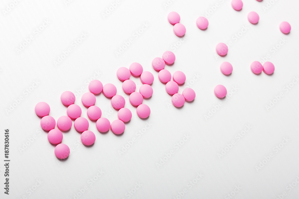Inscription of hope pink pills on white background
