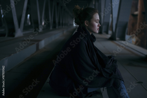 Caucasian woman sitting under bridge photo