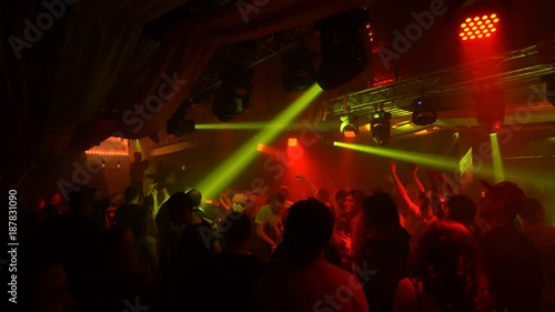 Ecstatic crowd in illuminated nightclub photo