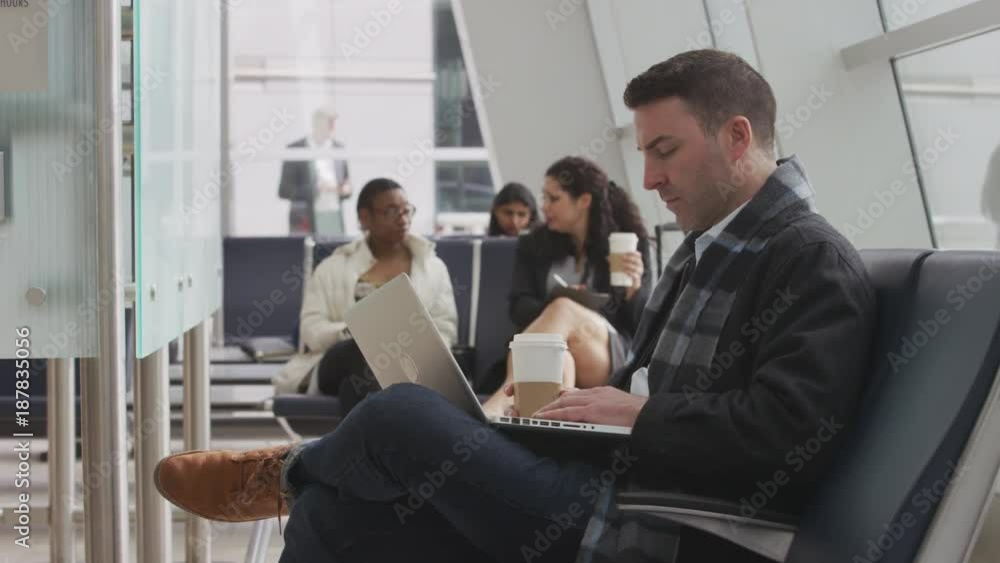 Businessman working on laptop at airport Businessman working on laptop at airport