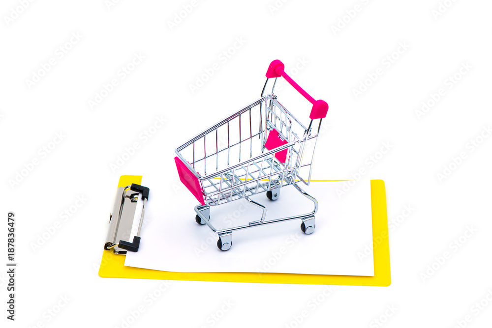Mini shopping cart or supermarket trolley on clipboard with blank white paper sheet, isolated on white background, business finance shopping concept.