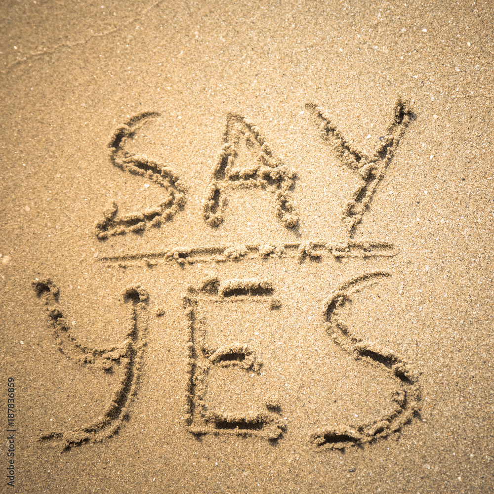 Fototapeta premium Say Yes word is written on the beach sand