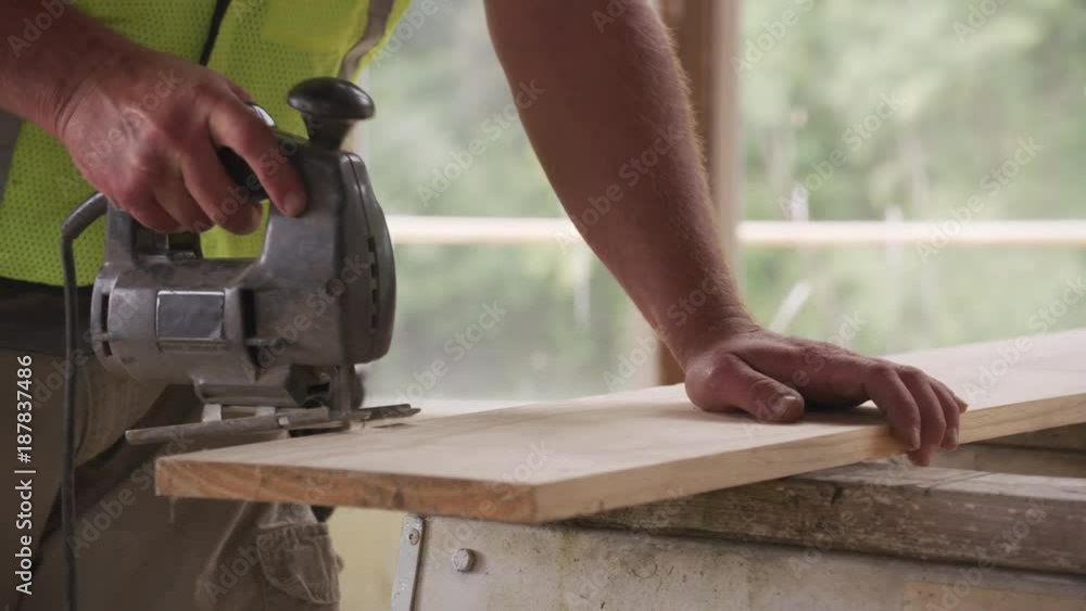 Closeup of construction worker using jigsaw Closeup of construction worker using jigsaw