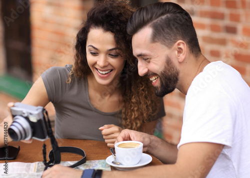 Young couple looking a photo of themselves in a cafe