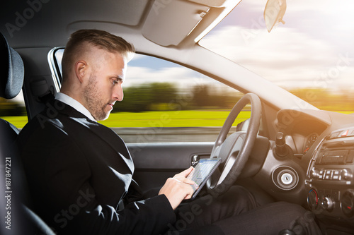 Businessman Sitting Inside Self Driving Car © Andrey Popov
