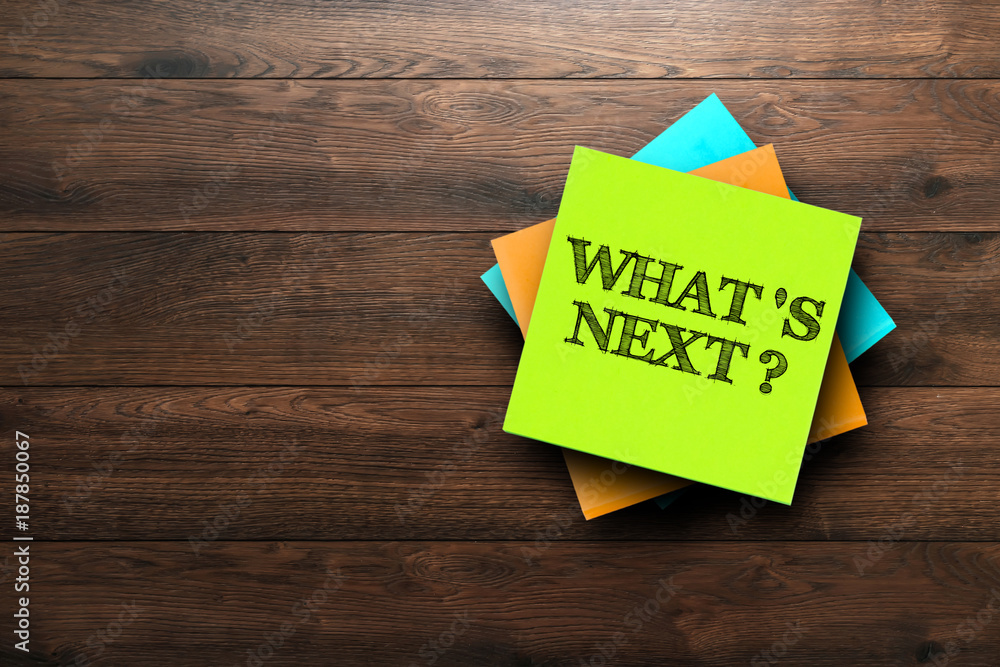 What's next, the phrase is written on multi-colored stickers, on a brown wooden background. Business concept, strategy, plan, planning. - obrazy, fototapety, plakaty 