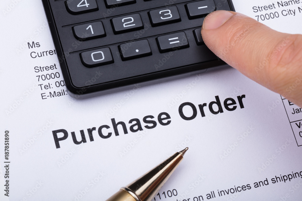 Person Using Calculator On Purchase Order Form Person Using Calculator On Purchase Order Form