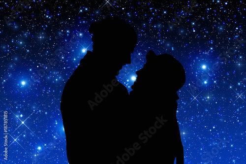 Silhouettes of a young couple under the starry sky. 