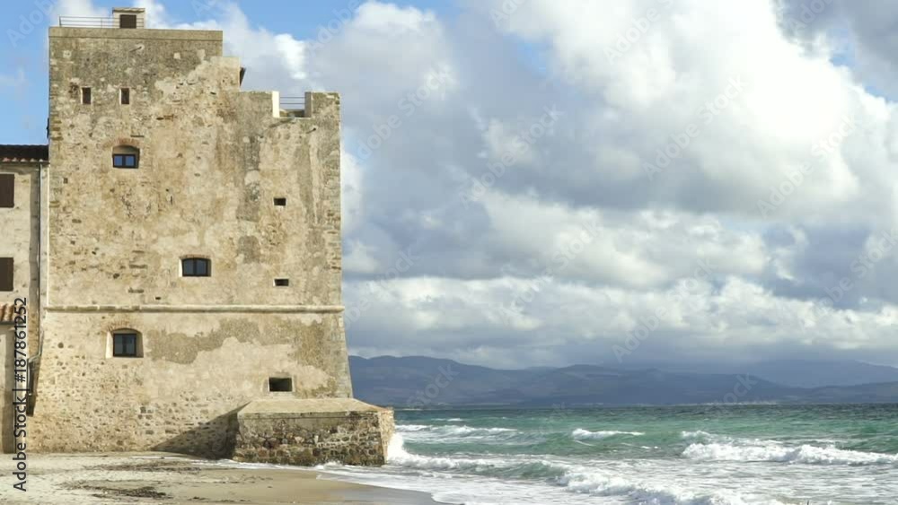 Sea waves near a tower of a coastal fortification on the beach, slowmo Sea waves near a tower of a coastal fortification on the beach, slowmo