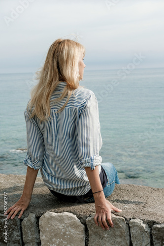 Back of blonde woman traveler enjoying the views on sea in summer. Montenegro