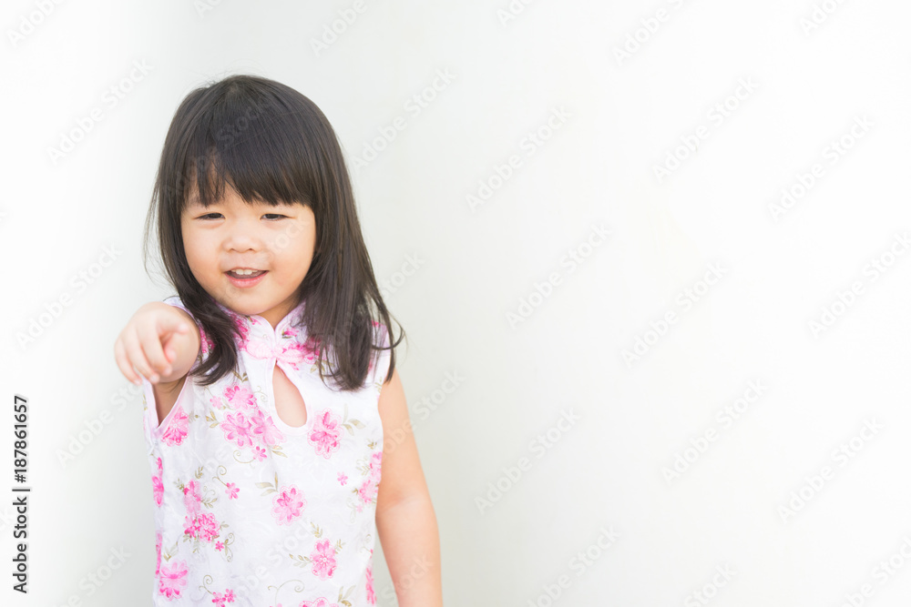 Happy Little asian girl in chinese traditional dress and pointing finger.Chinese new year concept. Happy Little asian girl in chinese traditional dress and pointing finger.Chinese new year concept.
