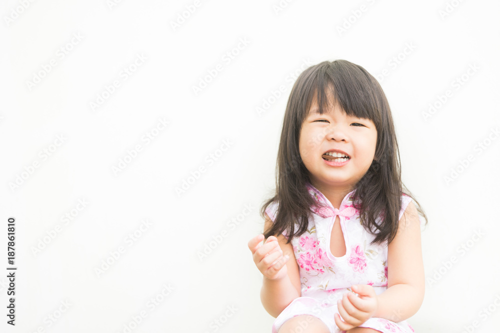 Happy Little asian girl in chinese traditional dress and eating chocolate candy, outdoor shoot on white background. Happy Little asian girl in chinese traditional dress and eating chocolate candy, outdoor shoot on white background.