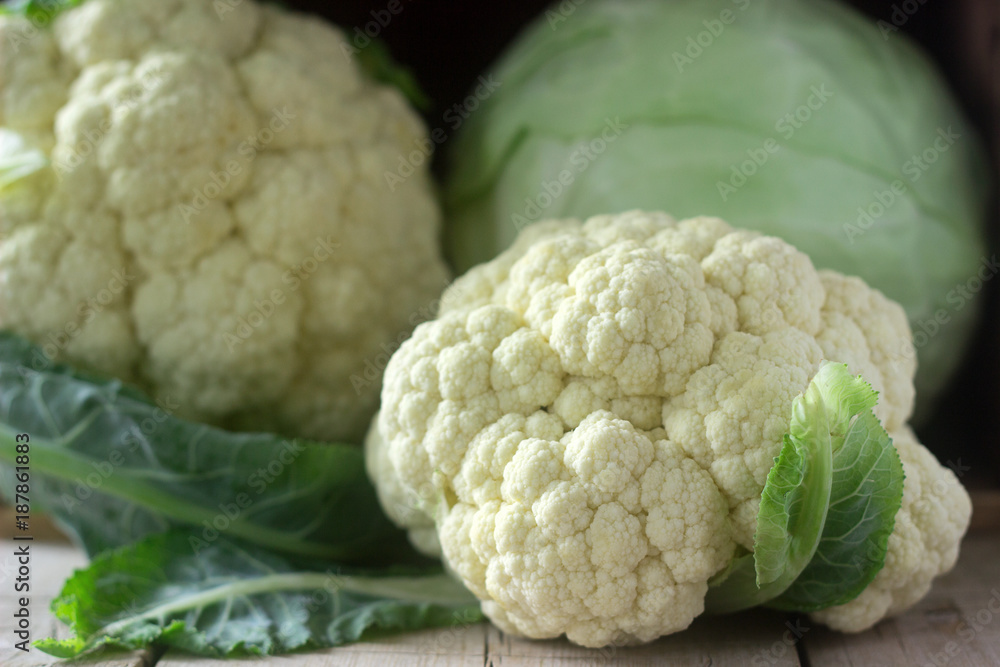 Cauliflower and cabbage on a wooden background. Rustic style, selective focus. Cauliflower and cabbage on a wooden background. Rustic style, selective focus.
