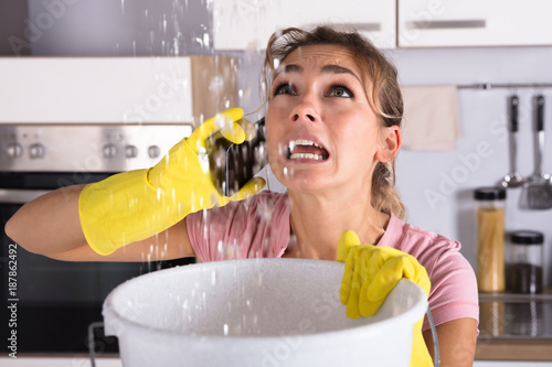 Woman Calling Plumber To Fix Water Leaking From Ceiling photo