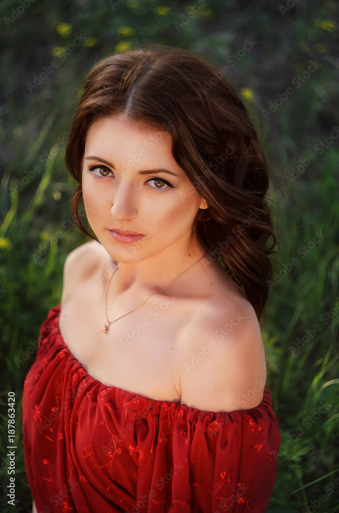 Naklejka premium girl in red dress in a field of flowers,oil brush, art photo, girl running in the field, girl walking in the nature