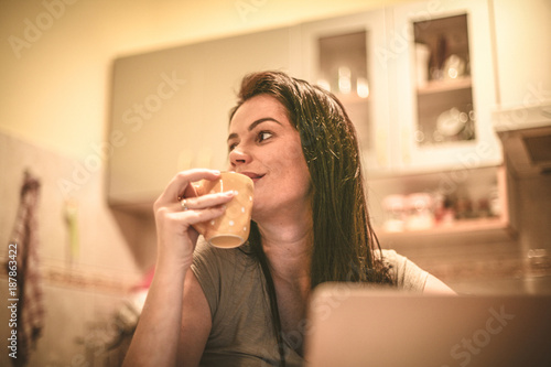 Young woman at home kitchen drinking coffee.