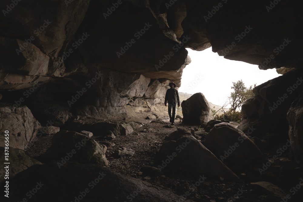 Male hiker entering inside the cave Male hiker entering inside the cave
