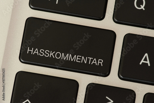 Ein Computer und eine Taste mit dem Aufdruck Hasskommentar