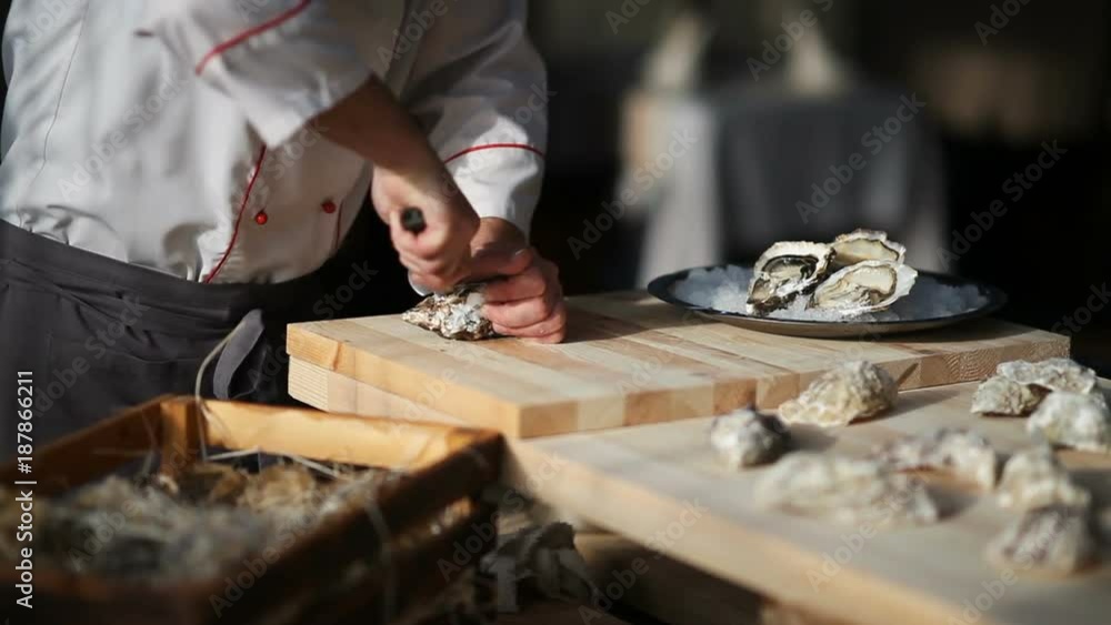 Chef trying to open fresh oyster in restaurant Chef trying to open fresh oyster in restaurant