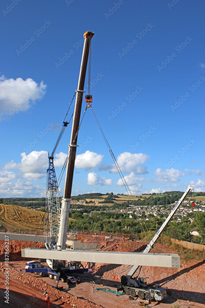 Crane lifting a concrete bridge beam