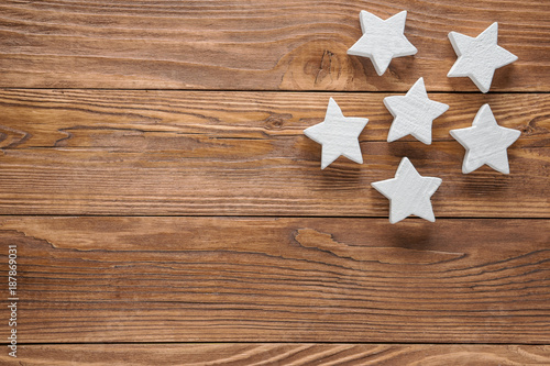 White wooden stars on brown wooden background, copy space, top view.