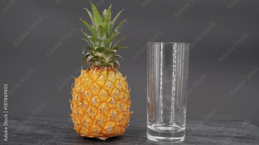 Pouring pineapple juice into glass isolated on black background Pouring pineapple juice into glass isolated on black background