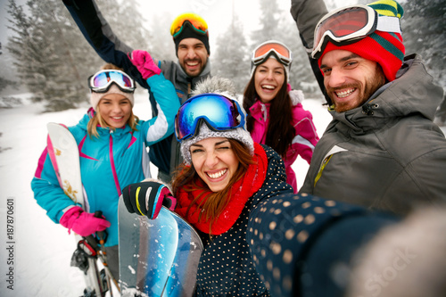 smiling friends having fun. Snowboarders and skiers making selfie