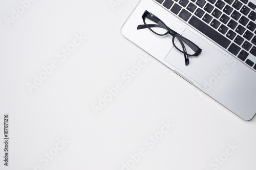 laptop computer and glasses on white background