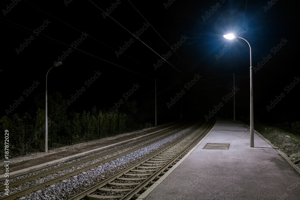 Ruhiger einsamer verlassener Bahnsteig bei Nacht mit Laternenlicht - obrazy, fototapety, plakaty 