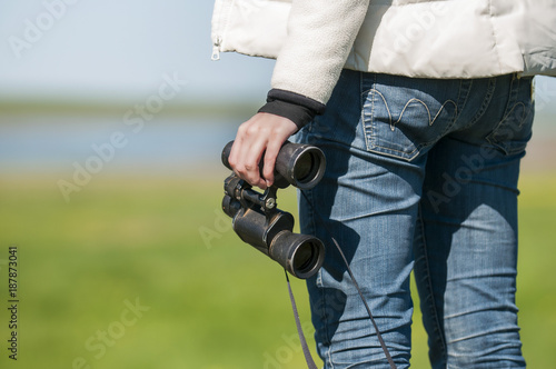Woman with binoculars in the endless steppe.