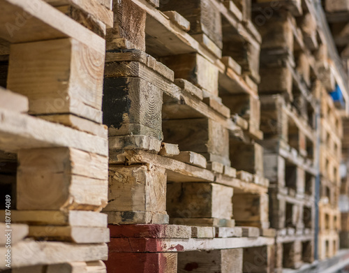 Stack of different wood pallets in warehouse. Selective focus.