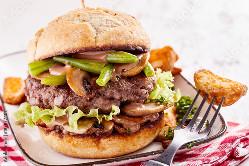 Beef burger with salad, mushrooms, fried potatoes