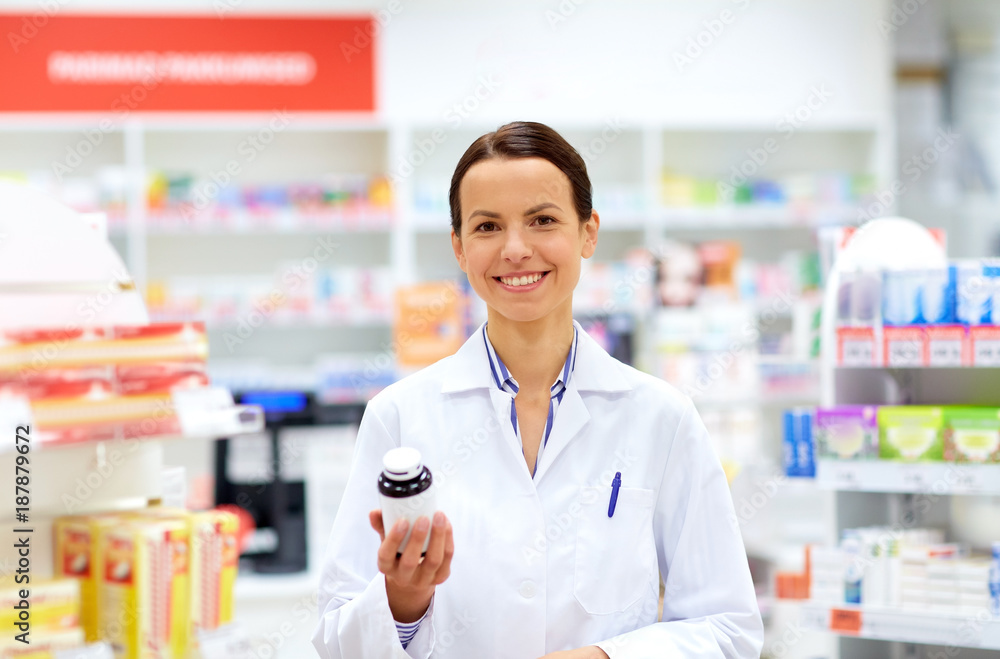 happy female apothecary with drug at pharmacy