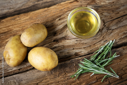 potatoes with rosemary and olive oil on wooden background