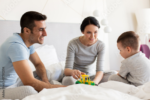 happy family in bed at home or hotel room