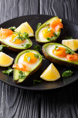 Healthy food baked avocado stuffed with egg and red fish closeup. vertical