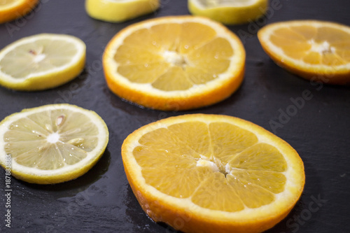 fettine di arance e limone su nero ardesia