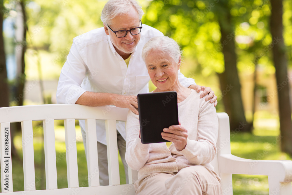 happy senior couple with tablet pc at summer park happy senior couple with tablet pc at summer park