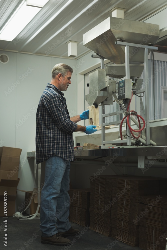 Man refining grain in machine Man refining grain in machine