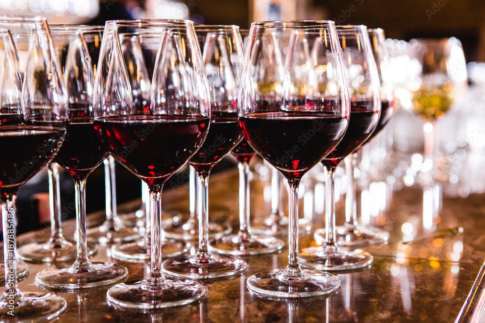 Glasses with red wine on blurred background.