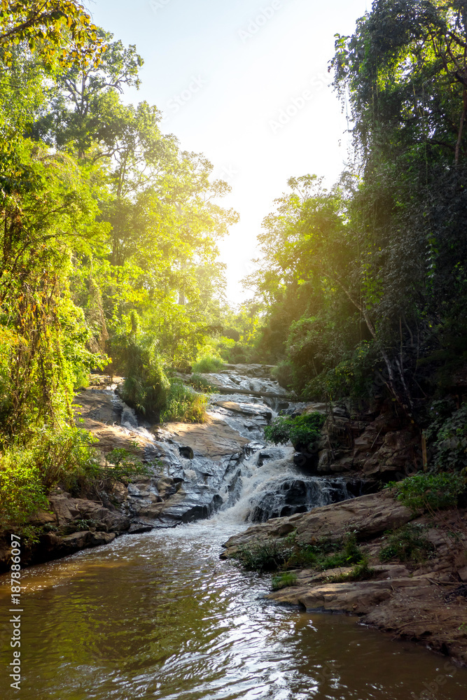 The beautiful waterfall in the national park in Thailand with lots of shade trees in the suny day. The beautiful waterfall in the national park in Thailand with lots of shade trees in the suny day.