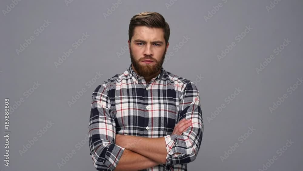 Serious bearded man in shirt looking at the camera with crossed arms over gray background
Serious bearded man in shirt looking at the camera with crossed arms over gray background