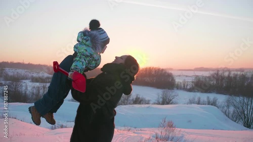 A young girl with a child playing in winter Park.Walks in the fresh air. Sunset