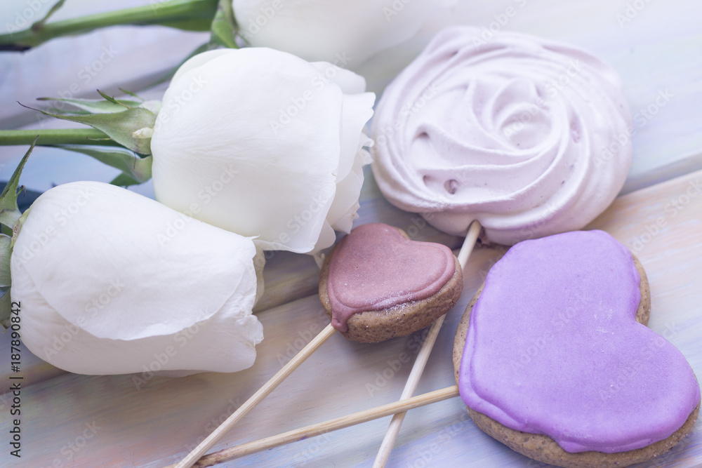The concept of Love, Wedding, Proposal, Anniversary, St. Valentine's Day, Mother's Day with beautiful white roses and ginger cookies in a close up, light wooden background The concept of Love, Wedding, Proposal, Anniversary, St. Valentine's Day, Mother's Day with beautiful white roses and ginger cookies in a close up, light wooden background